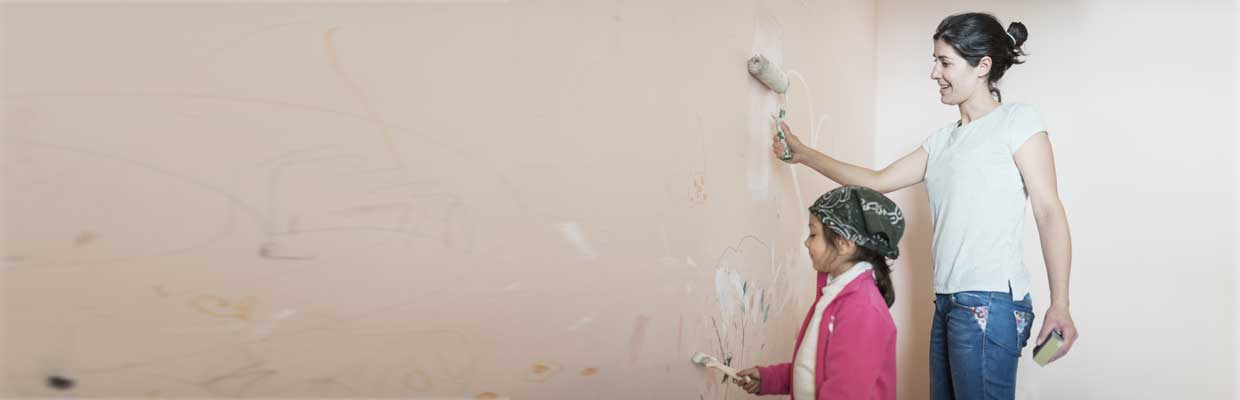 Mother and daughter painting a wall together; image used for HSBC Mauritius credit card support page.
